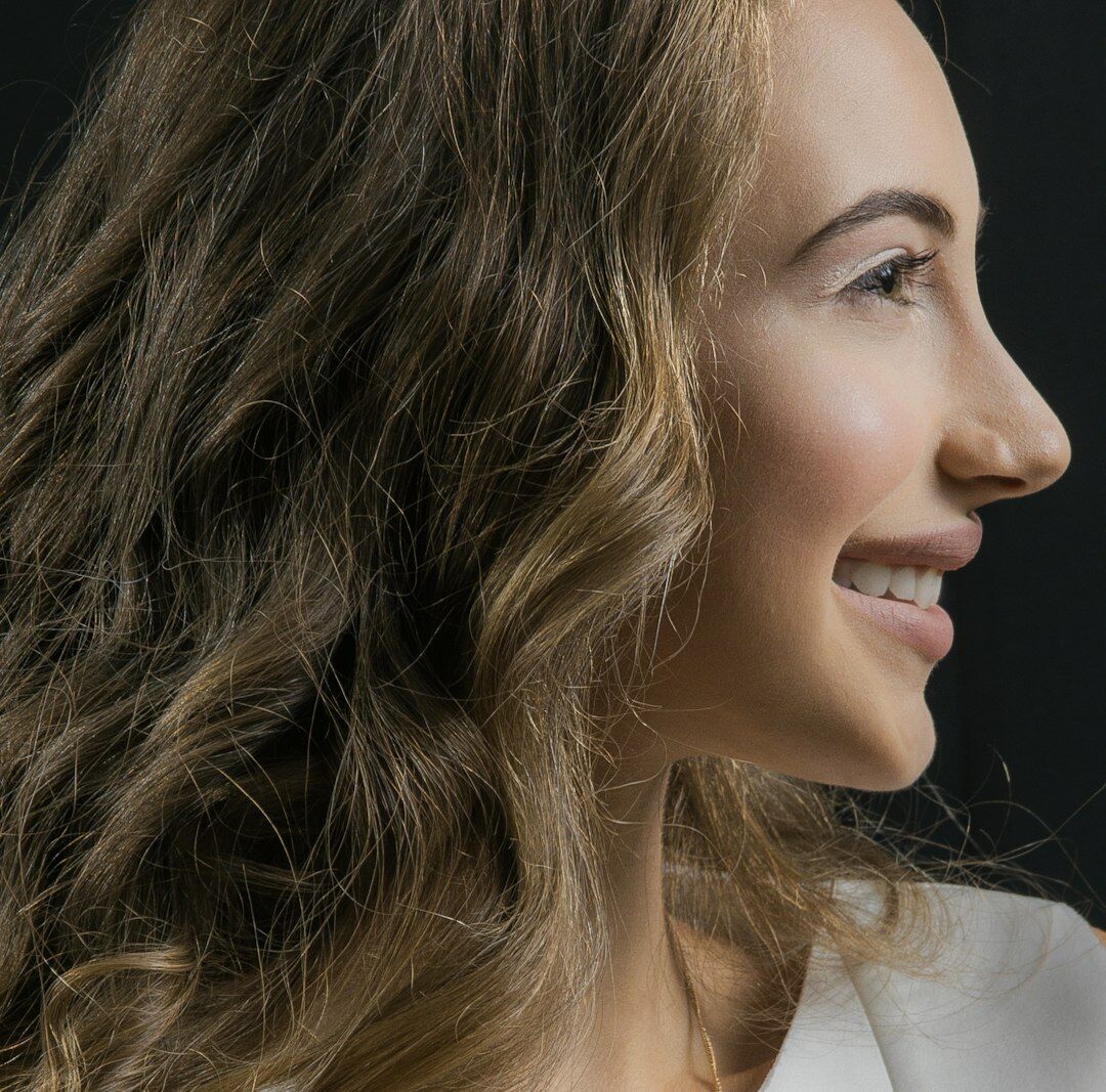 Studio portrait of a smiling Latin American woman with curly hair