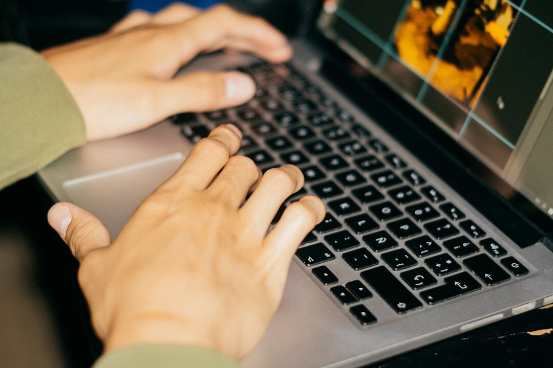 Hands typing on a laptop showing an entertainment news website